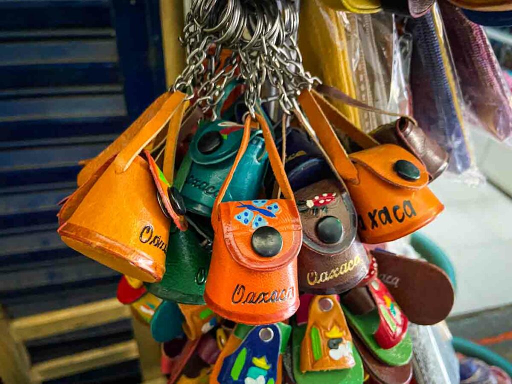 Collection of keychains for sale made from small leather pouches with Oaxaca written on them.